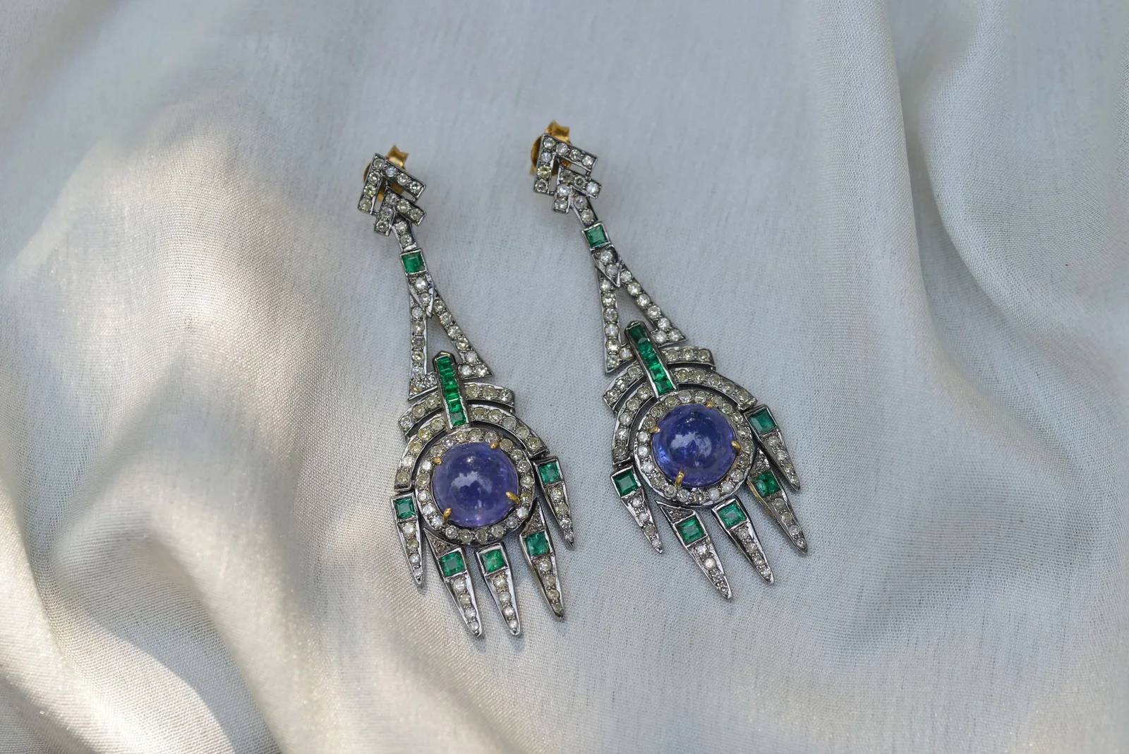 A pair of Art Deco drop earrings with blue, green and white stones, on silk