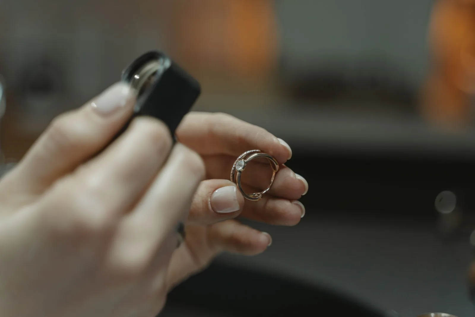Hands looking at a diamond ring through a loupe